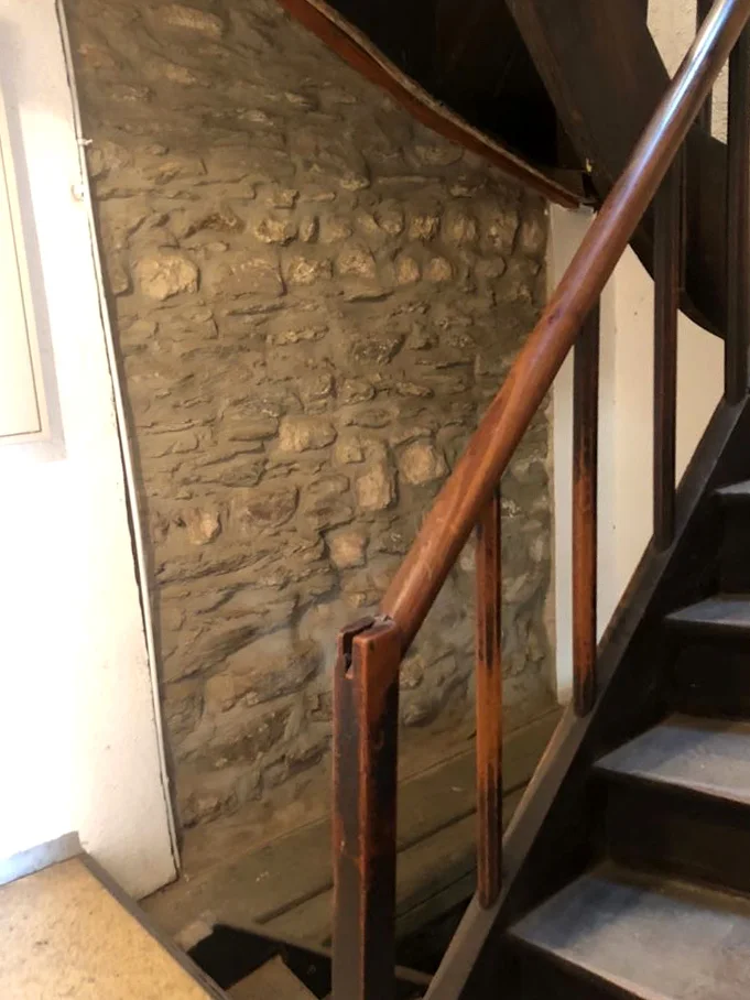 Treppenhaus mit alter innenliegender Stadtmauer